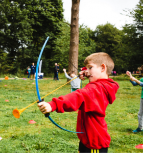 Child aiming a bow and arrow at a Premier Education Holiday Camp