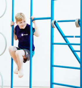Child doing gymnastics on a climbing frame