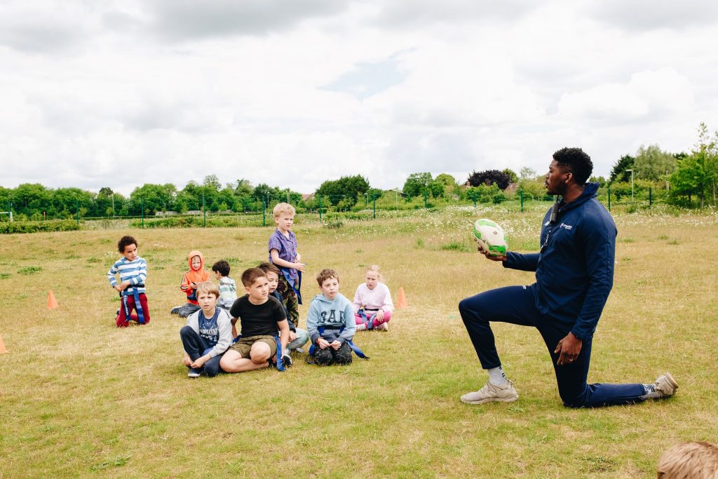 Premier Education sports coach teaching pupils how to play rugby 