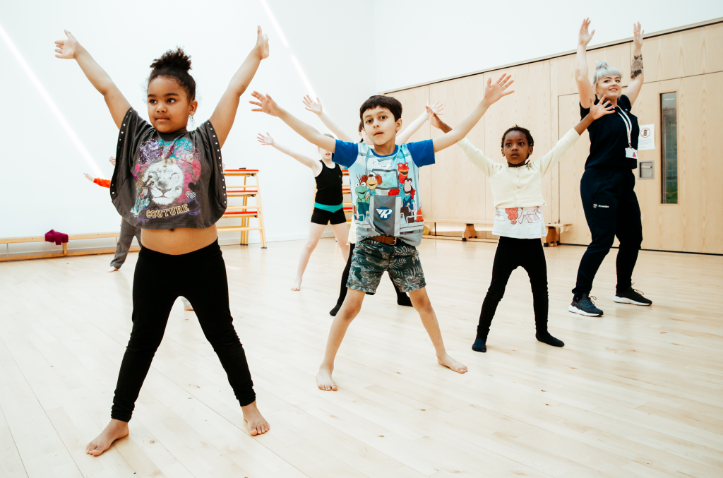 Pupils dancing with a Premier Education activity professional during a dance class
