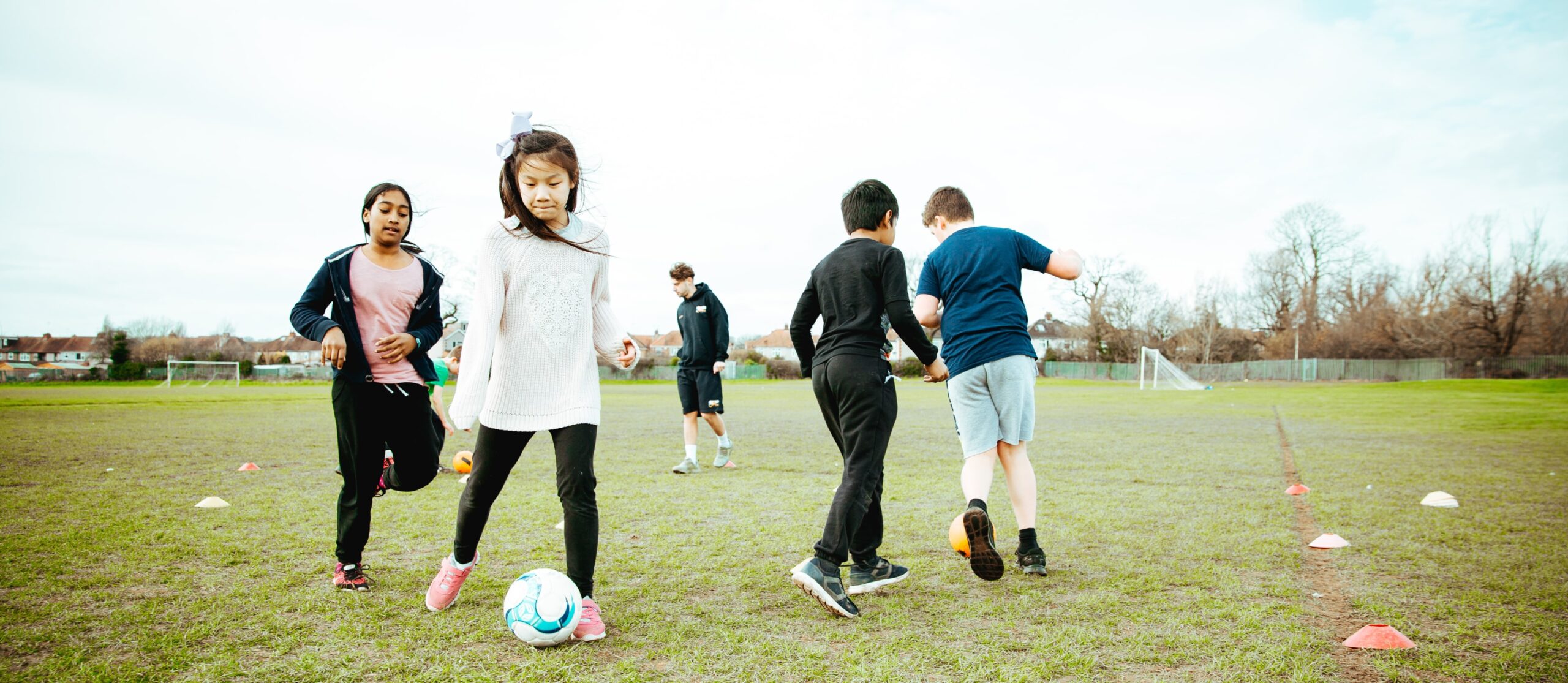 children dribbling a ball during pe