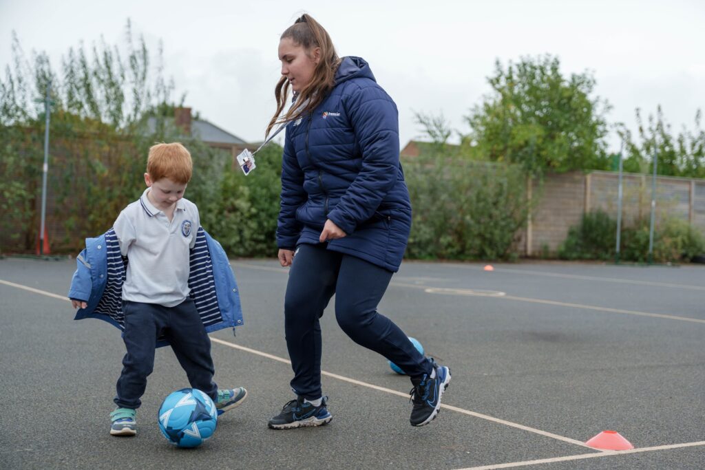 Extended Day Services that Premier Education Offers 4 Child and sports coach playing football